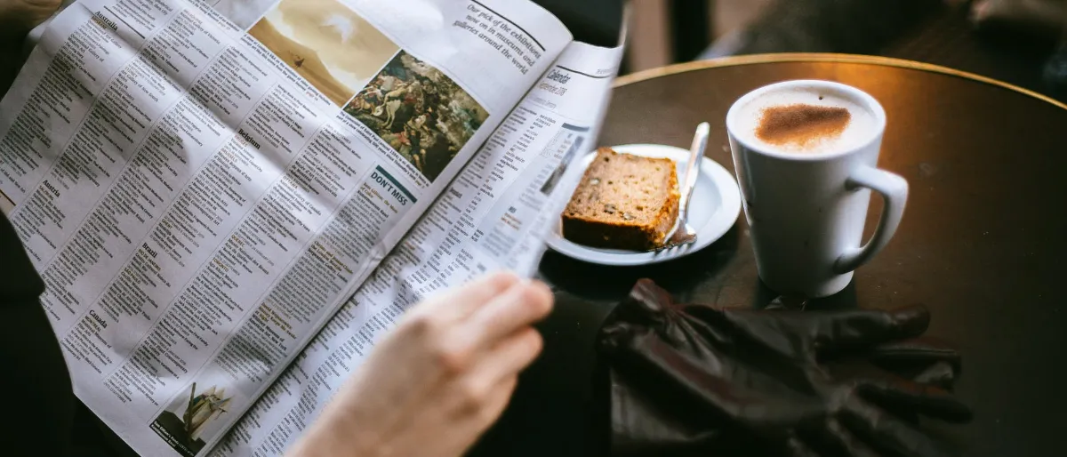 Reading a newspaper with coffee